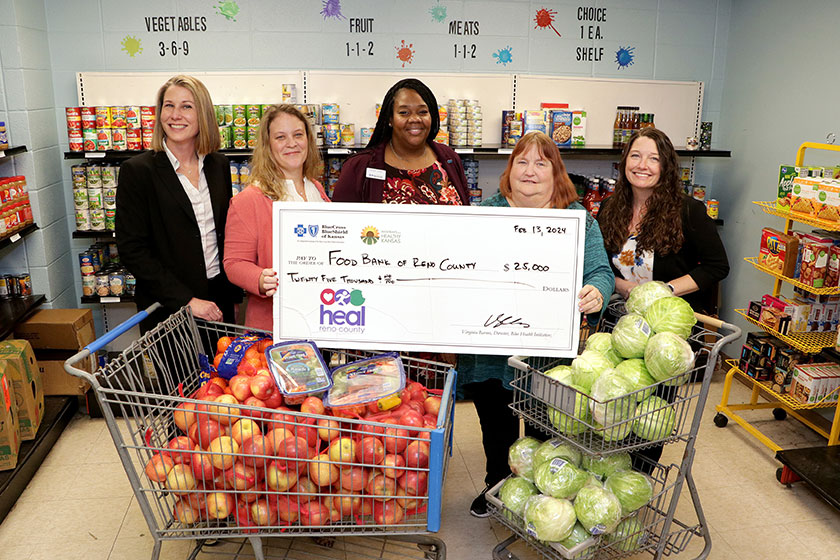 Recipients hold a giant check for Food Bank of Reno County