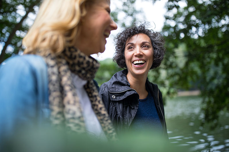 Two friends talking on wooded trail