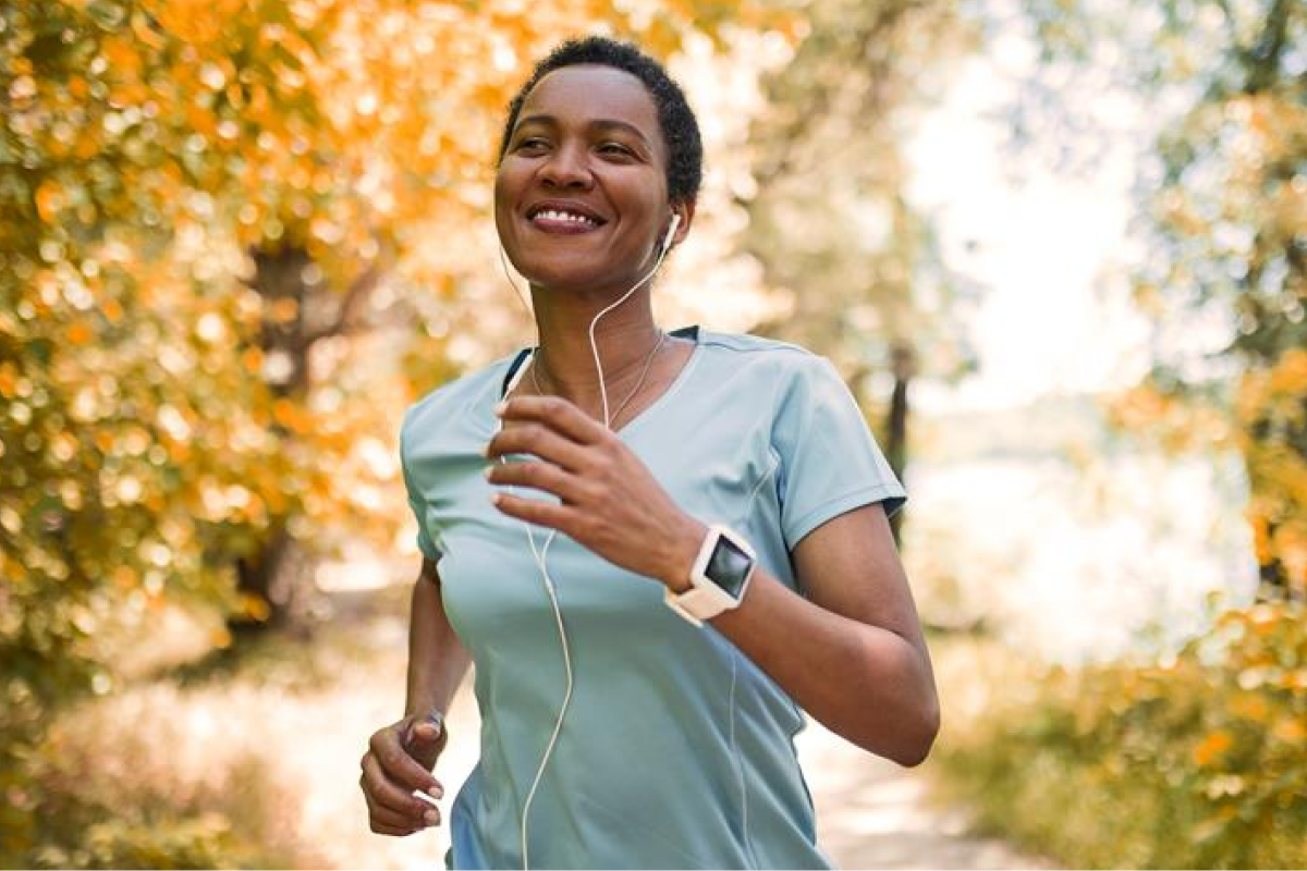 Happy woman jogging through the park