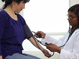 A doctor taking their patient's blood pressure