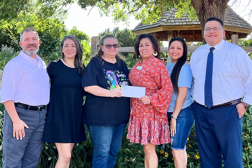 Six people pose in front of gazebo with Grant County check envelope