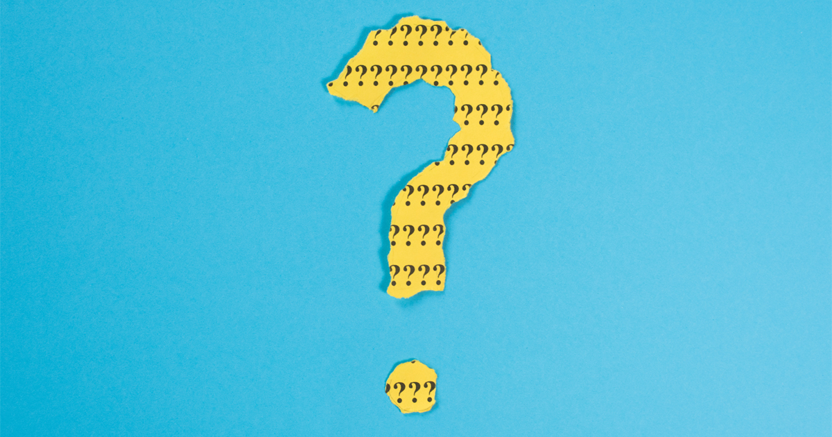 A question mark formed out of torn yellow paper with black question marks printed on it.