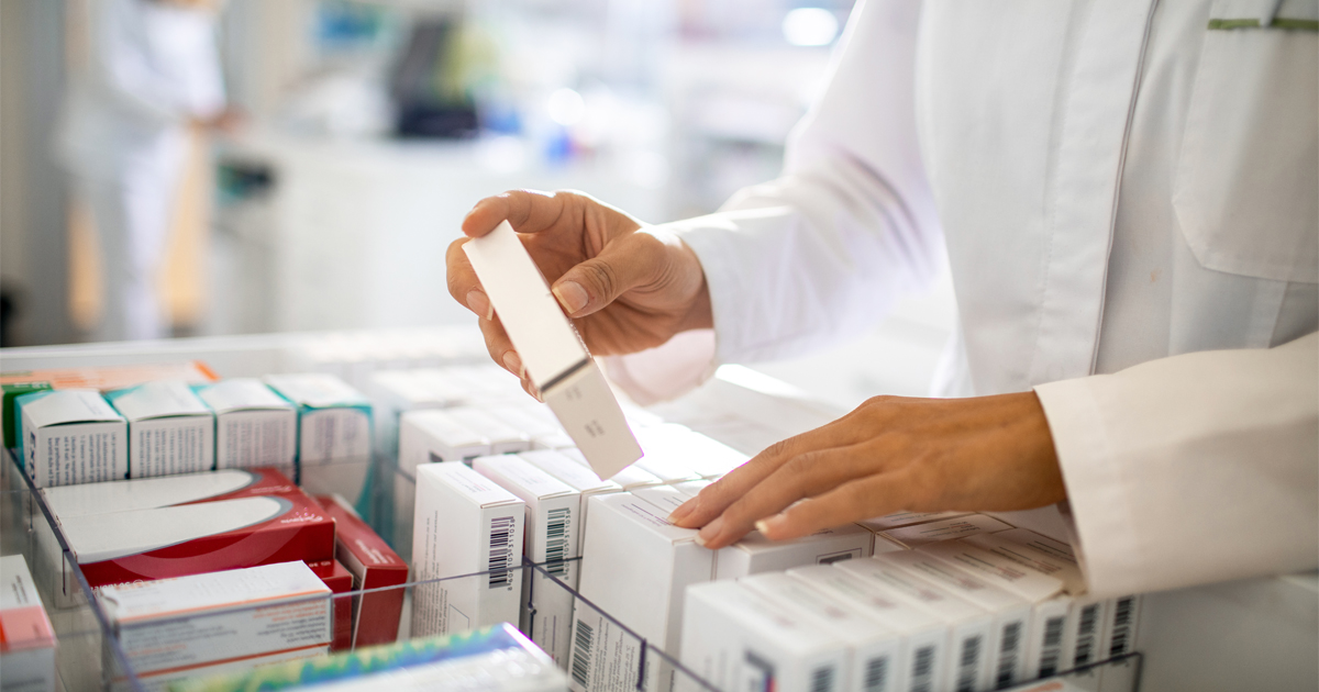 A pharmacist puts a medication box in a drawer