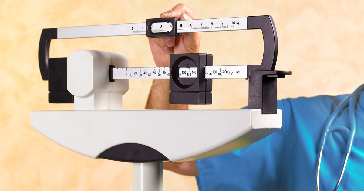 A doctor adjusts balances on a scale