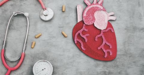 A stethoscope and pills next to an illustration of a human heart.