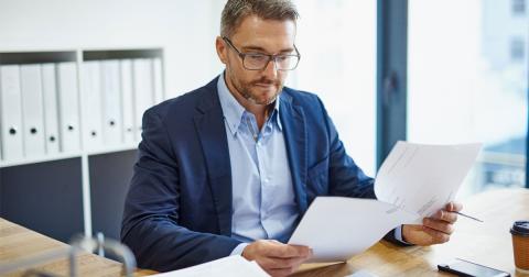 A man looks at some papers in an office